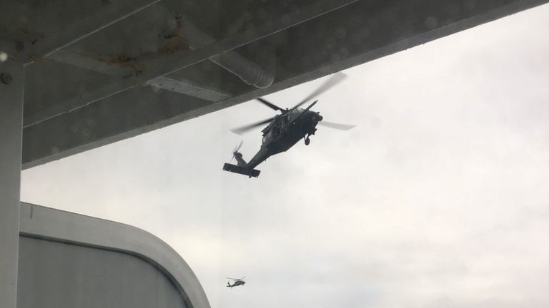 A helicopter hovers over the Grand Princess cruise ship