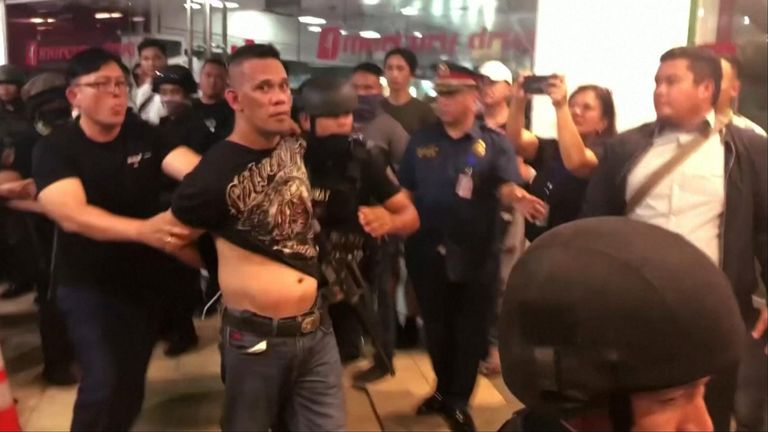 A sacked Philippine security guard was arrested after shooting a man and taking dozens of people hostage in a shopping centre in Manilla