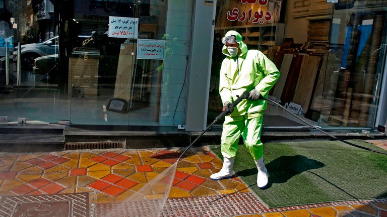 Iranian workers disinfect a street in Tehran