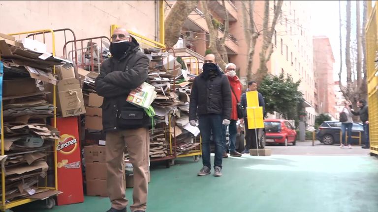 Italians queue to enter a supermarket in Rome