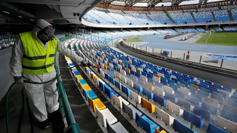 A cleaner sanitises seats at the San Paolo stadium