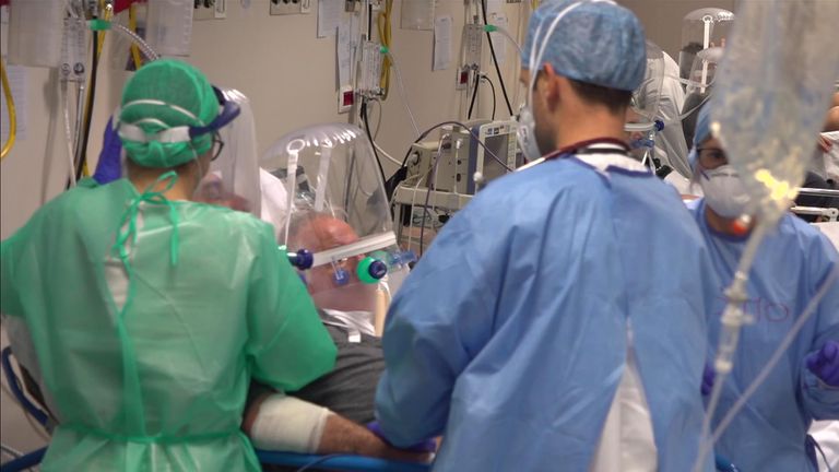 Medical staff crowd around a patient