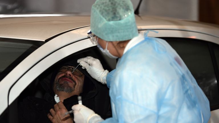A medical worker takes a nose swab at a drive-through facility in Liege, Belgium
