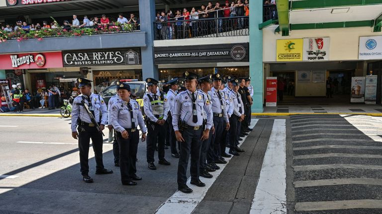 Security personnel gather outside the mall after the hostage situation was reported
