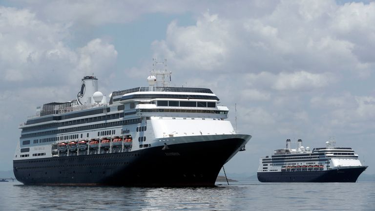 The Zaandam cruise ship, left, carrying some guests with flu-like symptoms, is anchored shortly after it arrived to the bay of Panama City