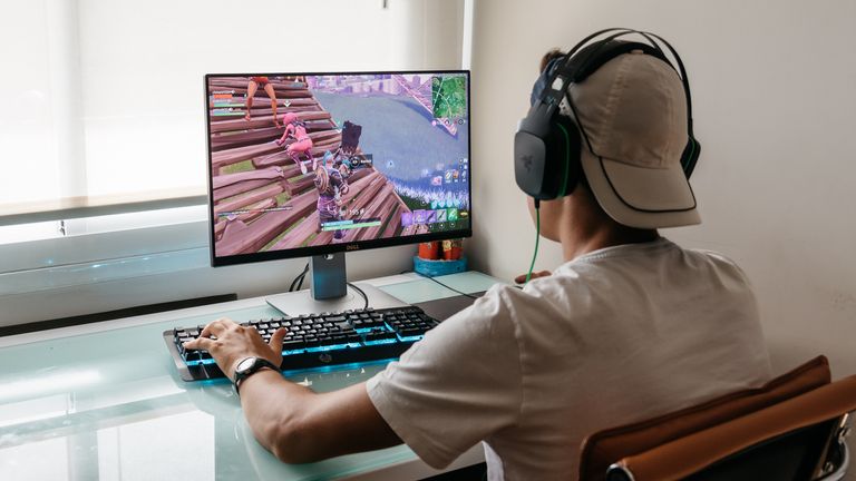 Madrid, Spain - August 15, 2018: Teenager playing Fortnite video game on PC. Fortnite is an online multiplayer video game developed by Epic Games (Madrid, Spain - August 15, 2018: Teenager playing Fortnite video game on PC. Fortnite is an online multi