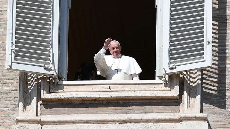 Pope Francis waves to people from his window after the live-broadcast of his Sunday Angelus prayer