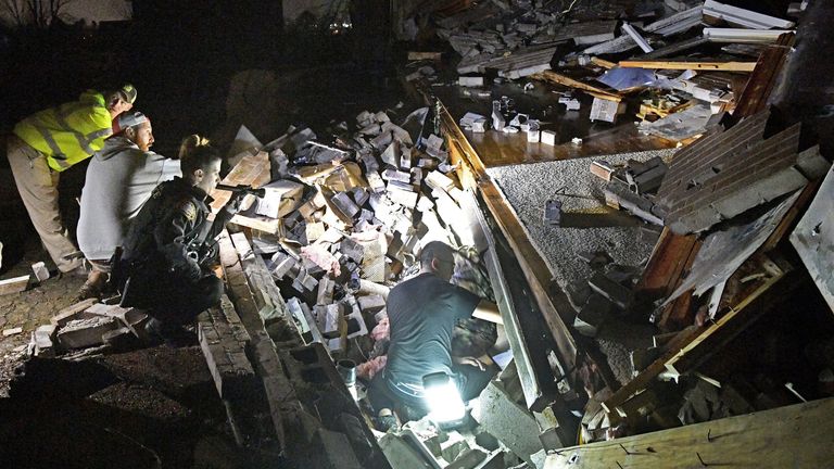 Rescuers work freed a couple from the rubble of their home home in Mt. Juliet, Tennessee