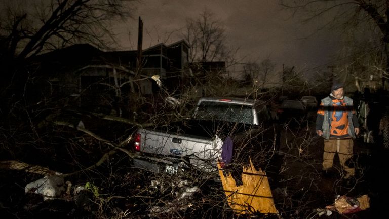 A man walks by a storm damaged pickup truck on Underwood St. on March 3, 2020 in Nashville, Tennessee
