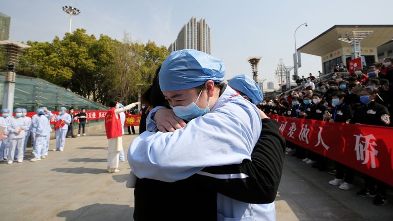 A Wuhan doctor hugs a medic from Jiangsu as he leaves after helping in the city's hospitals