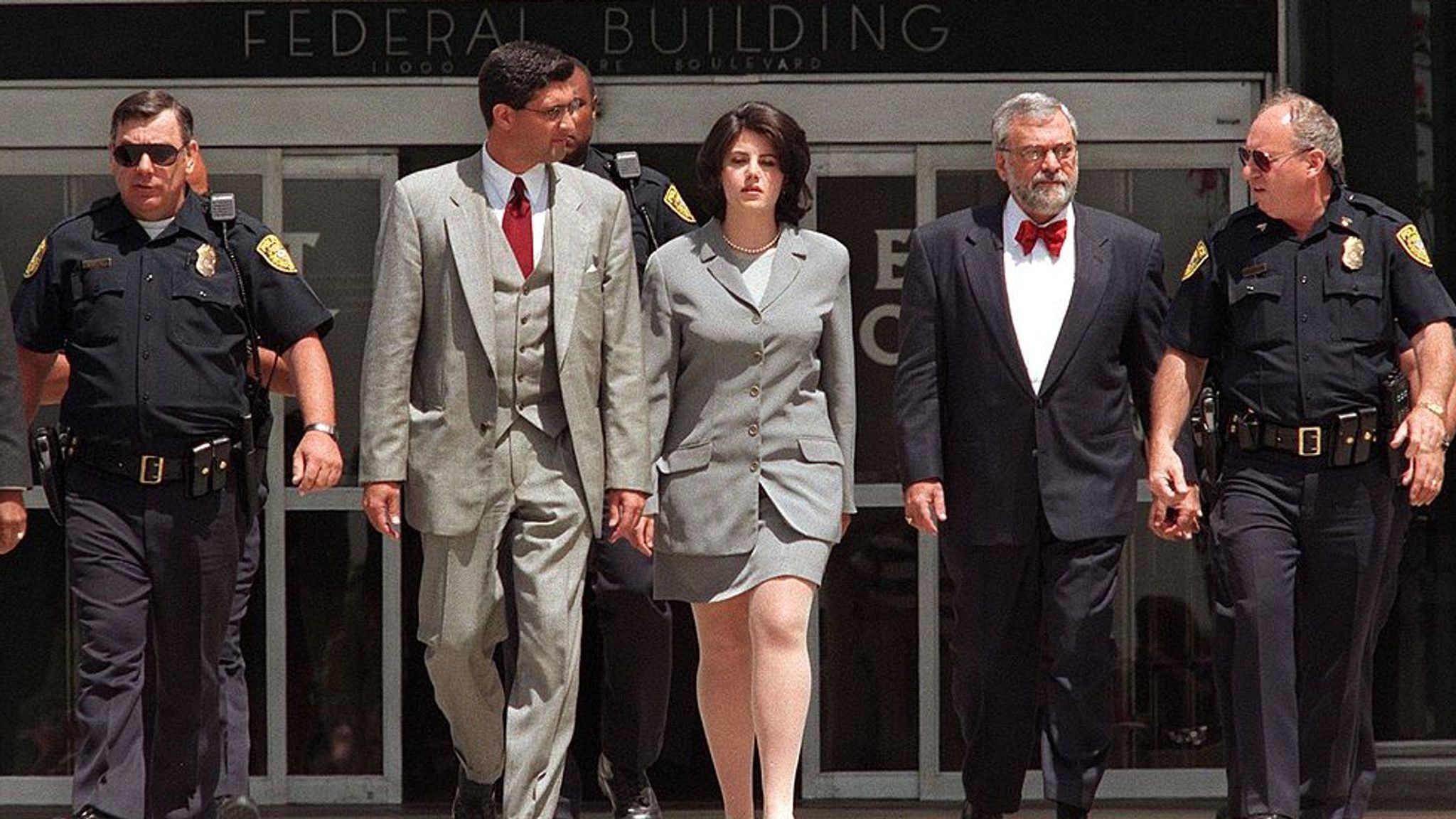 Monica Lewinsky (c) with police officers and her lawyer William Ginsburg in...