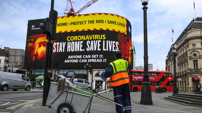 LONDON, ENGLAND - APRIL 08: A street cleaner is seen in front of Coronavirus messaging on Picadilly Circus on April 8, 2020 in London, England. Prime Minister Boris Johnson was transferred to the intensive care unit at St Thomas' Hospital after his coronavirus symptoms worsened on Monday night. (Photo by Peter Summers/Getty Images)