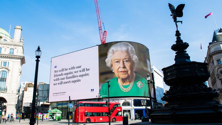 LONDON, ENGLAND - APRIL 10: An image of Queen Elizabeth II and quotes from her broadcast to the nation in relation to the coronavirus epidemic are displayed on screens in Piccadilly Circus on April 10, 2020 in London, England. (Photo by Samir Hussein/WireImage)