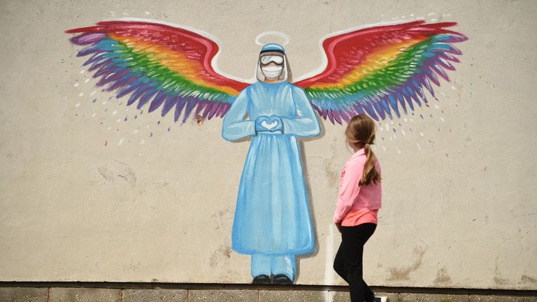 TOPSHOT - A girl looks at a mural by artist Rachel List paying tribute to NHS staff battling the COVID-19 outbreak painting on a wall in Pontefract, northern England, on April 23, 2020. (Photo by Oli SCARFF / AFP) / RESTRICTED TO EDITORIAL USE - MANDATORY MENTION OF THE ARTIST UPON PUBLICATION - TO ILLUSTRATE THE EVENT AS SPECIFIED IN THE CAPTION (Photo by OLI SCARFF/AFP via Getty Images)