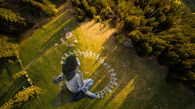 An artwork called "Beyond Crisis" by French artist Guillaume Legros aka Saype and created with an eco paint made out of chalk and coal over a 3000 sqm field is pictured during the coronavirus disease (COVID-19) outbreak in Leysin, Switzerland, April 24, 2020 in this picture obtained by Reuters April 26, 2020.  Valentin Flauraud/SAYPE/Handout via REUTERS THIS IMAGE HAS BEEN SUPPLIED BY A THIRD PARTY. NO RESALES. NO ARCHIVES