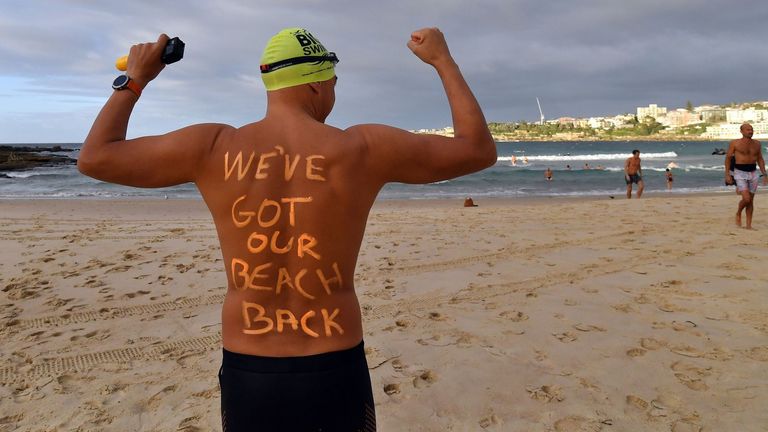 A man gets ready to enjoy his first swim in five weeks at Bondi Beach in Sydney after it reopens following closure over the coronavirus outbreak