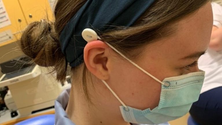 An NHS worker in Leicester wears a headband, made by teacher Caitlin McReynolds-White, to help make her PPE mask more comfortable