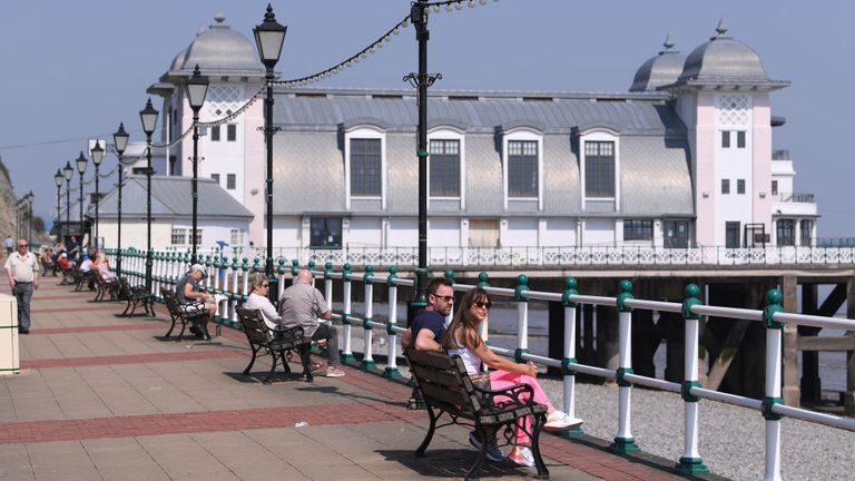 PENARTH, WALES - APRIL 25: People enjoy the spring sunshine whilst social distancing on Penarth Pier promenade on April 25, 2020 in Penarth, Wales. The British government has extended the lockdown restrictions first introduced on March 23 that are meant to slow the spread of COVID-19. (Photo by Stu Forster/Getty Images)
