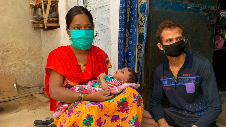 Mariam, left, and Mujibur with their son who was born during the running of the bulls  