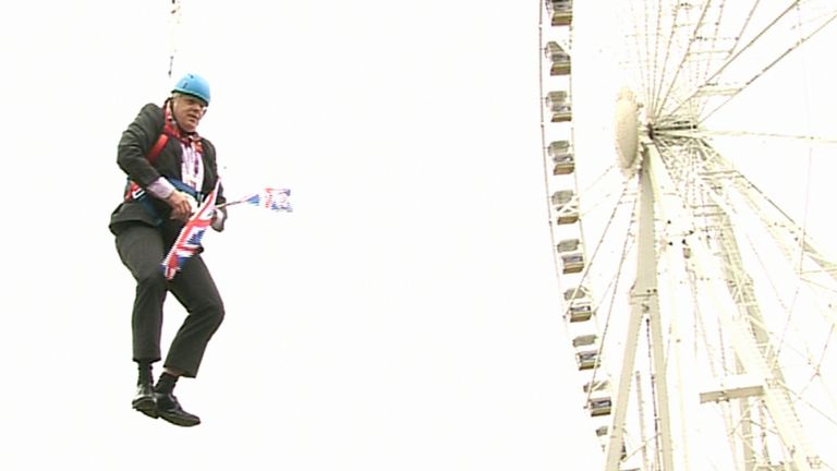 London Mayor Boris Johnson as he is left hanging in mid-air after he got stuck on a zipwire at an Olympic event at Victoria Park in the capital. 2012