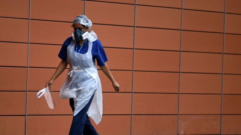 A nurse wears a protective face mask as she walks outside The Royal London Hospital in east London 