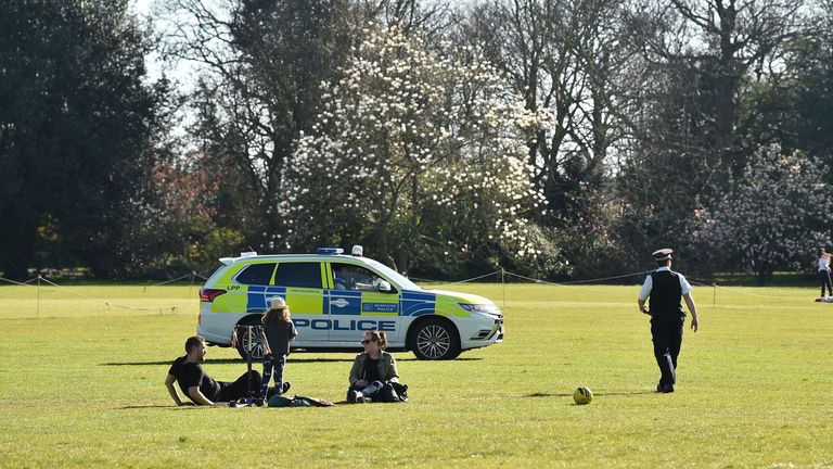 Police officers monitor as people take their daily exercise in Greenwich Park in south London on April 4, 2020, as life continues in the city during the novel coronavirus COVID-19 pandemic. - Britain on Friday reported a record 684 new COVID-19 deaths in its daily update, as the number of confirmed cases of coronavirus climbed by 4,450 on the previous 24 hours. (Photo by Glyn KIRK / AFP) (Photo by GLYN KIRK/AFP via Getty Images)