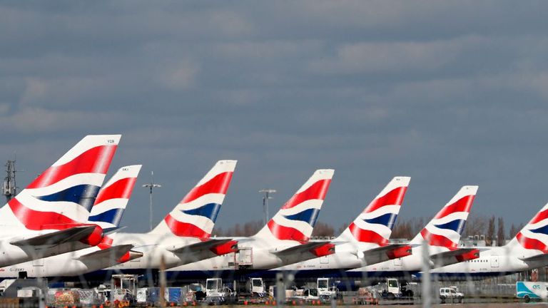 This picture shows British Airways planes grounded at Heathrow's airport terminal 5, in west London, on March 16, 2020. - IAG, the owner of British Airways and Spanish carrier Iberia, said Monday it would slash the group's flight capacity by 75 percent during April and May owing to the coronavirus outbreak. "For April and May, the Group plans to reduce capacity by at least 75 percent compared to the same period in 2019," it said in a statement. (Photo by Adrian DENNIS / AFP) (Photo by ADRIAN DEN