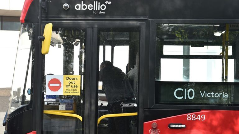 A sign reading "Doors out of use" is pictured on the front doors of a London bus