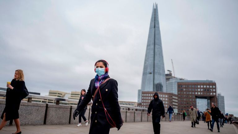 A commuter wears a mask whilst walking across a quiet London Bridge into the City of London during the morning rush hour on March 18, 2020 as people take precautions amid the coronavirus outbreak. - The British government will on Wednesday unveil a raft of emergency powers to deal with the coronavirus epidemic, including proposals allowing police to detain potentially infected people to be tested. (Photo by Tolga AKMEN / AFP) (Photo by TOLGA AKMEN/AFP via Getty Images)
