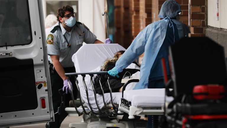 Medics bring in a patient at a coronavirus intake tent at Maimonides Medical Center in Brooklyn