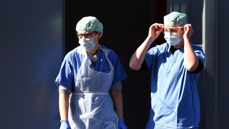 Medical staff members wearing PPE of gloves, eye protection, face masks and aprons, wait to test NHS workers for the novel coronavirus COVID-19, at a drive-in facility run by Wolverhampton NHS Clinical Commissioning Group, set up in a car park in Wolverhampton, central England on April 07, 2020. - British Prime Minister Boris Johnson spent the night in intensive care after being admitted with a deteriorating case of coronavirus, prompting serious concerns on Tuesday about his health and the gove