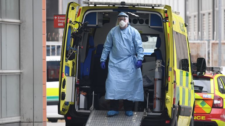 A health worker wear PPE as he stands in an ambulance after transferring a patient into The Royal London Hospital in east London on April 18, 2020, during the novel coronavirus COVID-19 pandemic