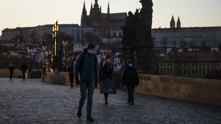 Prag'da yüz maskesi takan insanlar yürüyor