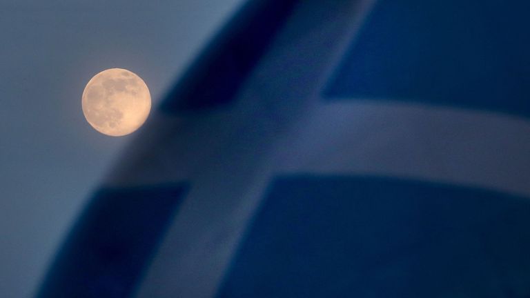 A pink supermoon is seen beside a Saltire flag in Falkirk