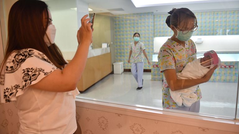 A newborn baby wearing a face shield, in an effort to halt the spread of the COVID-19 at Praram 9 Hospital in Bangkok