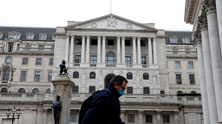 A man wearing protective face mask walks past the Bank of England in the City of London on March 30, 2020, as life in Britain continues during the nationwide lockdown to combat the novel coronavirus pandemic. - Life in locked-down Britain may not return to normal for six months or longer as it battles the coronavirus outbreak, a top health official warned on Sunday, as the death toll reached passed 1,200. (Photo by Tolga AKMEN / AFP) (Photo by TOLGA AKMEN/AFP via Getty Images)