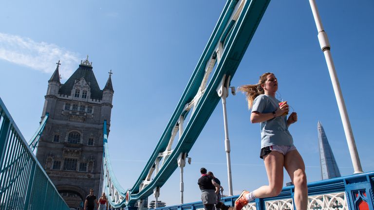A runner passes over Tower Bridge, in central London, on the course of the London Marathon, which was postponed to help curb the spread of the coronavirus.
