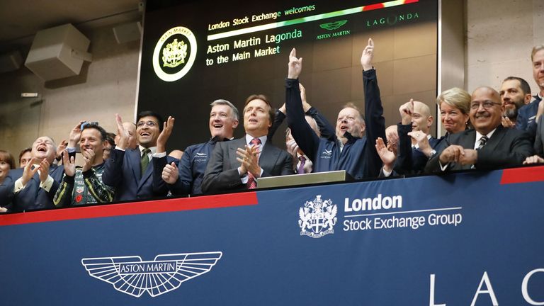 Andy Palmer (C), CEO of luxury British sports car manufacturer Aston Martin raises his fists in celebration as the company was floated on the London Stock Exchange