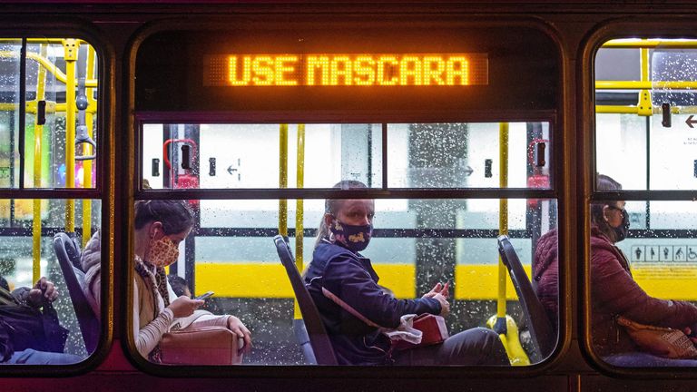 Commuters wearing face masks travel on a public bus with an electronic sign reading &#39;Wear a face mask&#39;, in Curitiba, Brazil 