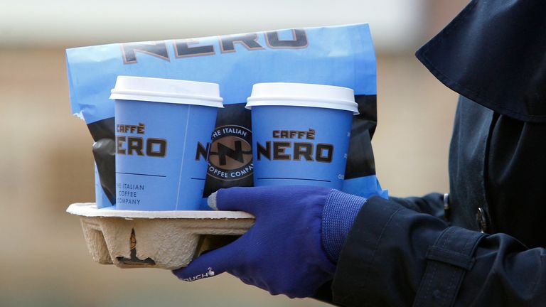 A lady walks with take away Caffe Nero cups. February 12, 2014