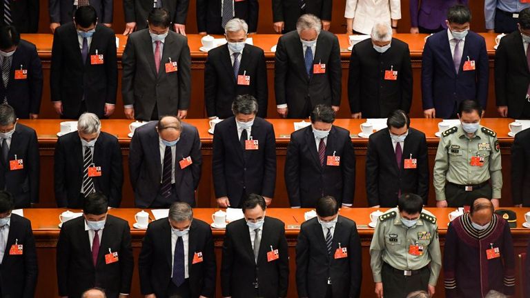 Delegates stand in silent tribute for victims of the COVID-19 during the opening session of the Chinese People&#39;s Political Consultative Conference (CPPCC) 