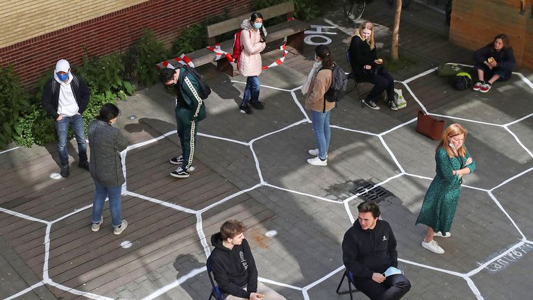 Students wearing protective face masks practice social distancing at the courtyard of the flemish secondary school during its reopening in Brussels, as a small part of Belgian children head back to their schools with new rules and social distancing measures, during the outbreak of the coronavirus disease (COVID-19), in Brussels, Belgium, May 15, 2020. REUTERS/Yves Herman