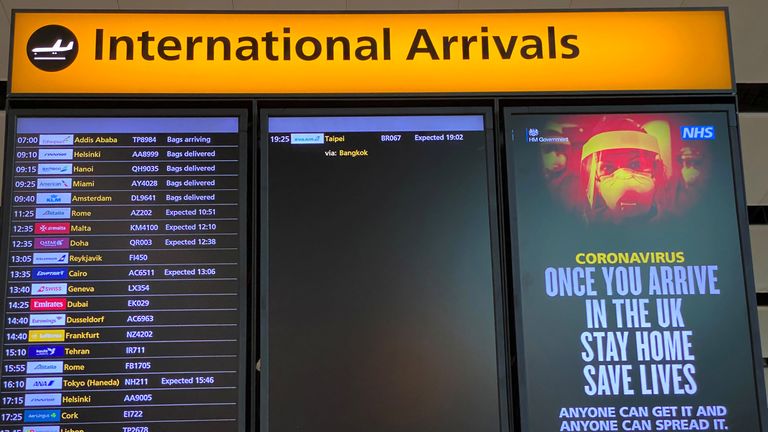 A public health campaign notice is displayed on a flight information screen at Heathrow Airport,