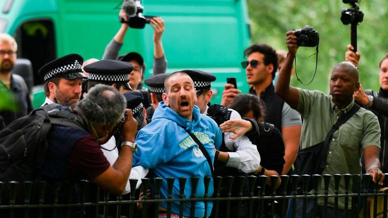 A man is arrested by police as media with cameras and smartphones surround at an anti-coronavirus lockdown demonstration in Hyde Park in London on May 16, 2020, following an easing of lockdown rules in England during the novel coronavirus COVID-19 pandemic. - Fliers advertising 'mass gatherings' organised by the UK Freedom Movement to oppose the government lockdown measures and guidelines put in place to halt the spread of coronavirus in parks around the UK calling for attendees to bring a picni