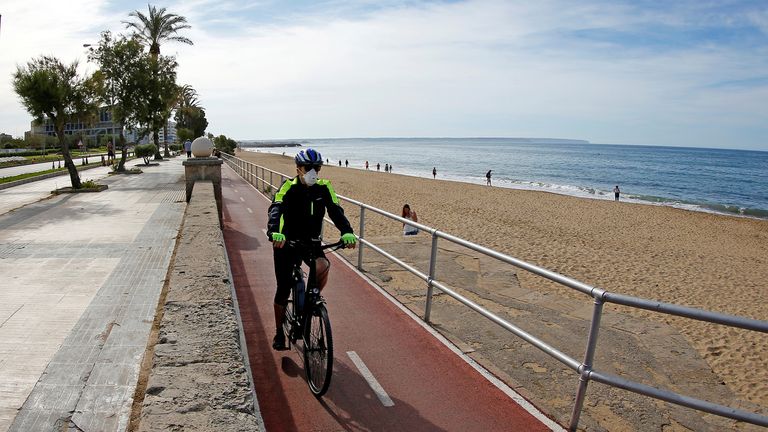 A man rides on a bicycle next to the Can Pere Antoni beach in Palma de Mallorca during the hours in which individual exercise is allowed outdoors, for the first time since the lockdown was announced, amid the coronavirus disease (COVID-19) outbreak, in Palma de Mallorca, Spain, May 2, 2020.  REUTERS/Enrique Calvo