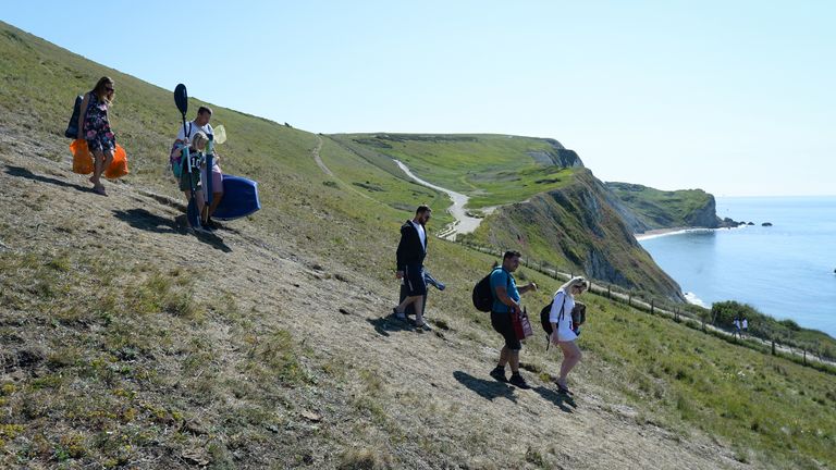 LULWORTH, ENGLAND - MAY 25: Tourists make their way to Durdle Door beach on May 25, 2020 in West Lulworth, United Kingdom. The British government has started easing the lockdown it imposed two months ago to curb the spread of Covid-19, abandoning its &#39;stay at home&#39; slogan in favour of a message to &#39;be alert&#39;, but UK countries have varied in their approaches to relaxing quarantine measures. (Photo by Finnbarr Webster/Getty Images)