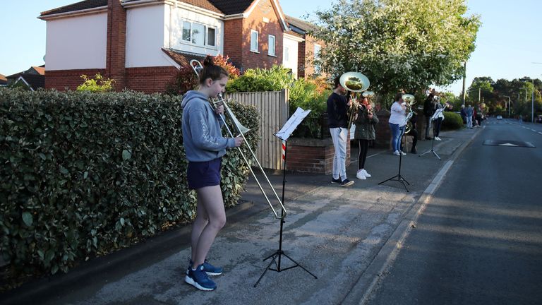 People play brass instruments on the street in Davenham during the clap for carers campaign