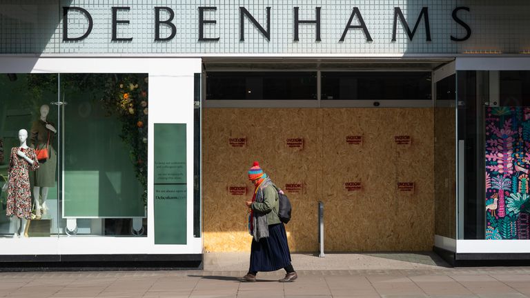 A person walks past a boarded up Debenhams, Oxford Street