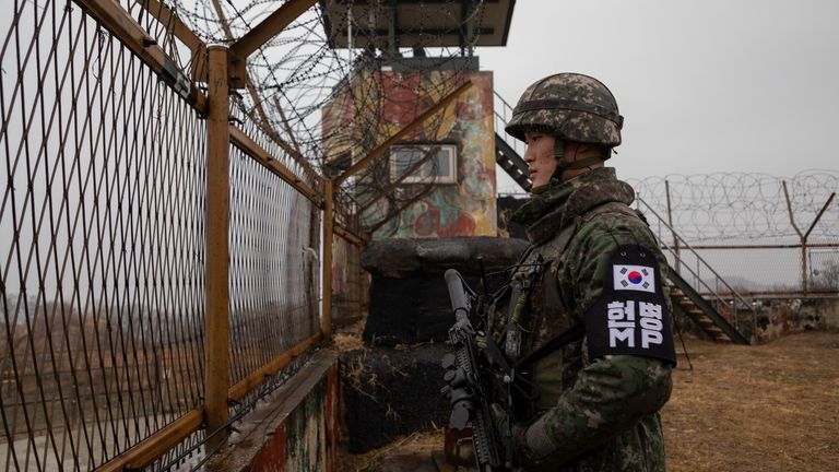 In a photo taken on December 3, 2018 a South Korean soldier stands before a security fence at a guard post inside the Demilitarized Zone (DMZ) near the Military Demarcation Line (MDL) separating North and South Korea, in South Korea&#39;s Cheorwon county