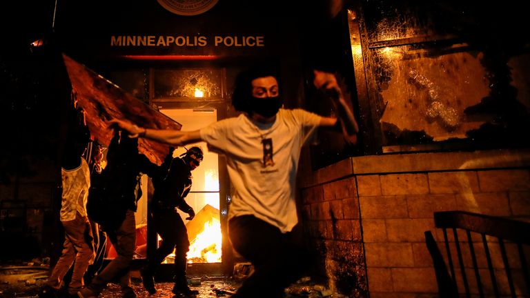 Protesters set fire to the entrance of a police station during a third night of violence